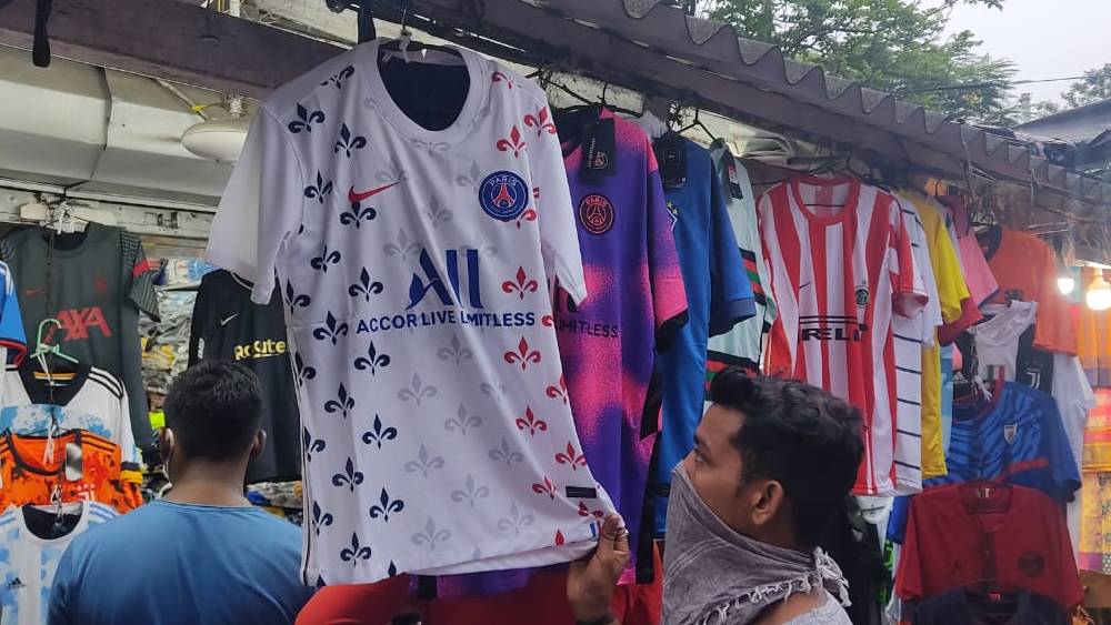 পিএসজি-র জার্সি দেখছেন এক ক্রেতা 