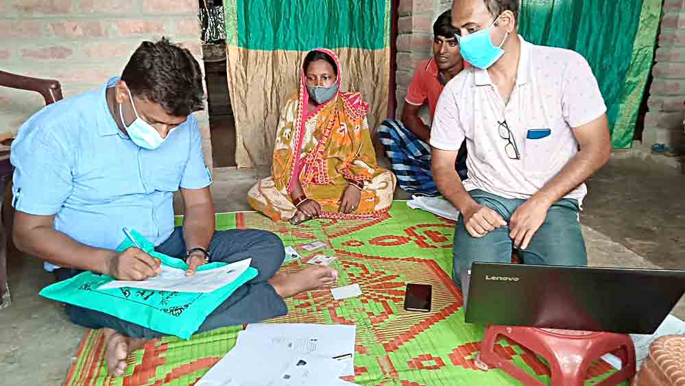 বাড়িতে গিয়ে পূরণ করা হচ্ছে ফর্ম। নিজস্ব চিত্র।