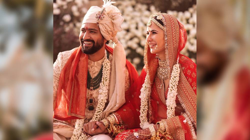 ঘিয়ে রঙা শেরওয়ানি আর পাগড়িতে বরবেশে ভিকি। গায়ে চাপিয়েছেন একই রঙের উত্তরীয়। দুপুর সাড়ে তিনটে নাগাদ সাতপাক ঘুরেছেন দুই তারকা। শিশমহলে বসেছিল বিয়ের মণ্ডপ। হলুদ, কমলা, গোলাপি পর্দা ঘেরা মণ্ডপে কনে এসেছেন কাচের কাজ করা পাল্কিতে। বর এসেছেন সাদা ঘোড়ায় চেপে। 