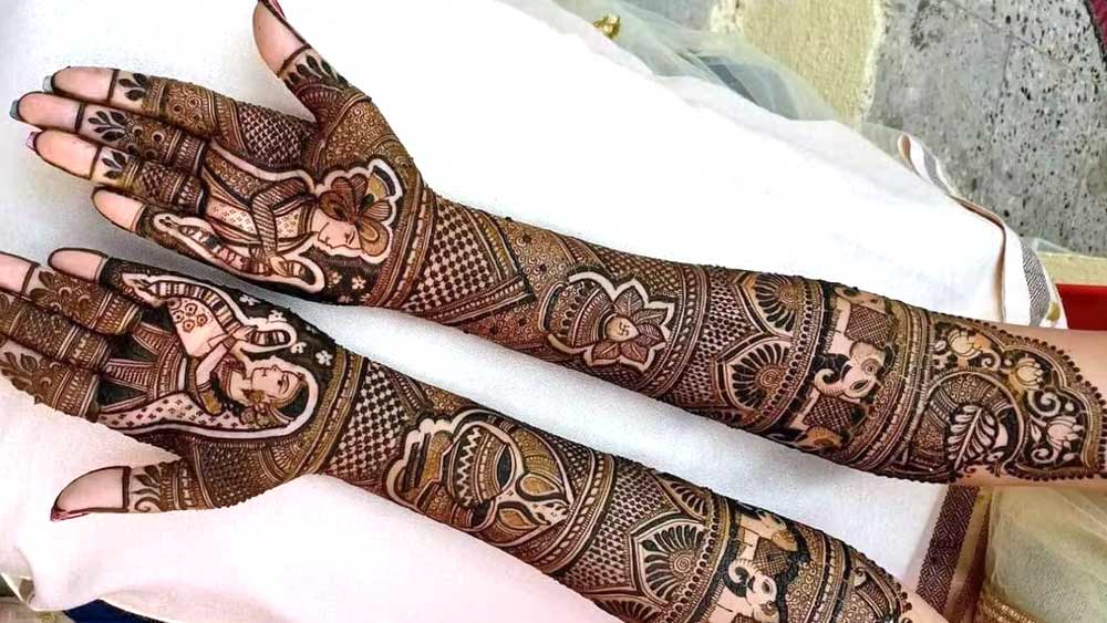 ১০. রাজকীয় ঘরানার যুগলবন্দি: রাজস্থানি এবং মুঘল নকশার মেলবন্ধন ফুটে ওঠে এই মেহেন্দির নকশায়। বর-বউয়ের বিয়ের দৃশ্যে ভরে ওঠে দুই হাত।