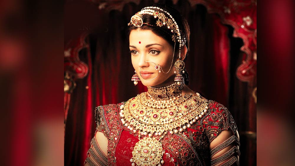 যোধা আকবর:  শীতের বিয়েতে ইদানীং জমকালো সাজে নজর কাড়ছেন অনেক হবু কনেই। আপনারও যদি এমন সাজ পছন্দ হয়, তবে পছন্দের তালিকায় রাখতেই পারেন আপনি আশুতোষ গোয়ারিকর পরিচালিত ‘যোধা আকবর’এ ঐশ্বর্যা রায় বচ্চনের সাজটি। সূক্ষ্ম পুঁতির কারুকাজ করা লেহঙ্গার সঙ্গে গলা ভর্তি হার, কানের ভারী দুল, টিকলি, আর নথ। মুঘল ঘরানার জাঁকজমকপূর্ণ সাজে সব মিলিয়ে রানির মতো লাগবে আপনাকে। 