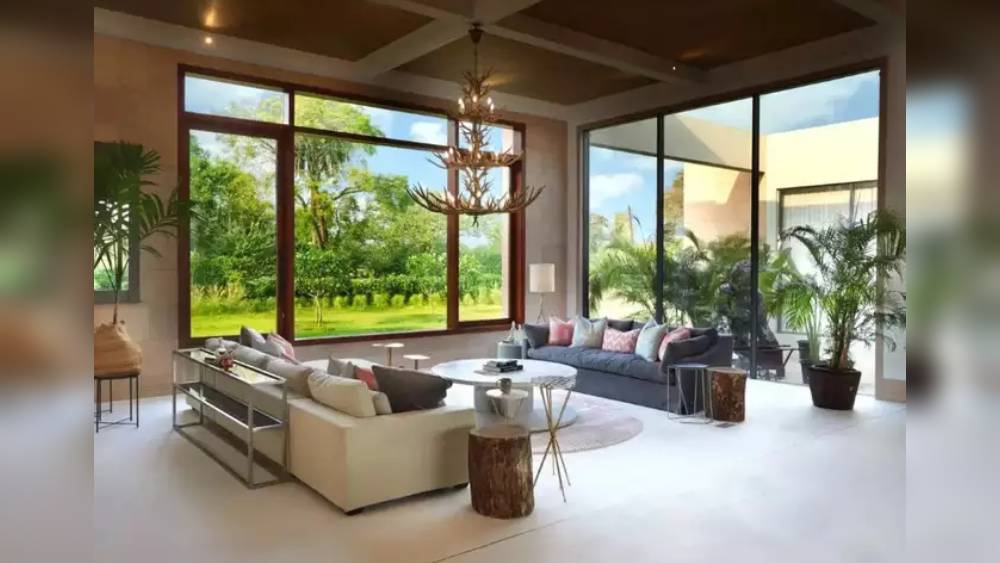 লিভিংরুম। বাড়ির অবসর যাপনের ঘরটি বেশ বড়। দেওয়ালজোড়া কাচের জানলা পেরিয়ে দেখা যাচ্ছে বাগানের দৃশ্য। ঘরের ভিতরে মুখোমুখি বড় দু’টি সোফার মাঝখানে ঝুলছে ঝাড়লণ্ঠন। দেখে বোঝা যায় সময় নিয়ে সাজানো হয়েছে জায়গাটি।