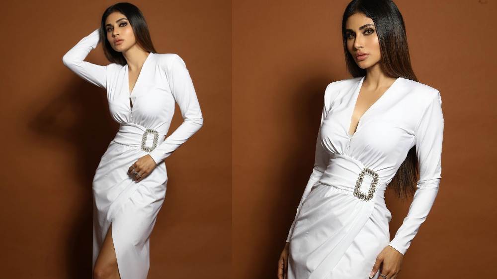 ধবধবে সাদাও কিন্তু এই মরসুমে নজর কাড়তে পারে। শরীর-চুম্বী বডিকন ড্রেস যদি থাকে, তা হলে আপনিও মৌনী রায়ের মতো সেজে উঠুন। সাদা রঙের পোশাক হলে রূপটানে নাটুকে ছোঁয়া রাখতেই পারেন। চুলের কায়দায় থাকুন মৌনীর মতোই স্নিগ্ধতা।