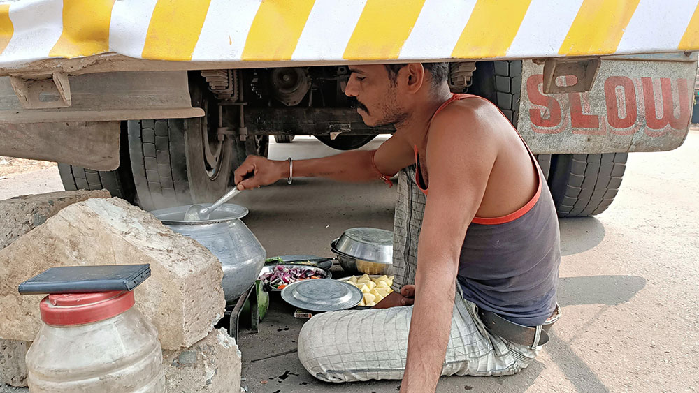 বিষ্ণুপুরের বাঁকাদহ গ্রামের কাছে বৈতল মোড়ে অবরুদ্ধ জাতীয় সড়কে ট্রাকের নীচেই রান্না। 