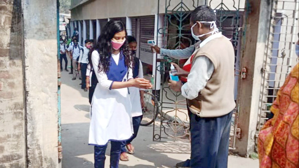 মংলামাড়ো মঙ্গলা অ্যাকাডেমিতে পড়ুয়াদের থার্মাল স্ক্রিনিং। নিজস্ব চিত্র।