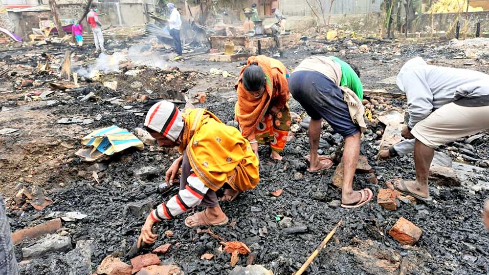 মরিয়া: পোড়া ধ্বংসস্তূপ থেকে শেষ সম্বলটুকু খোঁজার চেষ্টা। । শনিবার, সুভাষনগর রেল বাজারে। 