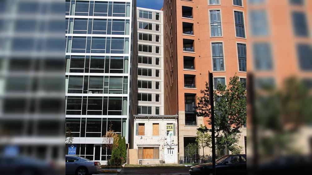 কাঁটা বাড়ি দেখা যাবে আমেরিকার ওয়াশিংটনেও। দু’টি বহুতলের মাঝখানে প্রায় হারিয়ে যাওয়া একটি দোতলা বাড়ি। বাড়ির দাম ২ লক্ষ মার্কিন ডলার। তবু বাড়িটি ভেঙে ফেলার জন্য বাড়ির মালিককে ৩০ লক্ষ মার্কিন ডলার ক্ষতিপূরণ দিতে চেয়েছিল নির্মণ সংস্থা। কিন্তু মালিক অস্টিন স্প্রিগ ওই প্রস্তাব মেনে নেননি। উল্টে ব্যাঙ্ক থেকে ঋণ নিয়ে নিজের বাড়িকে একটি পিৎজা রেস্তরাঁ বানিয়ে ফেলেন তিনি।