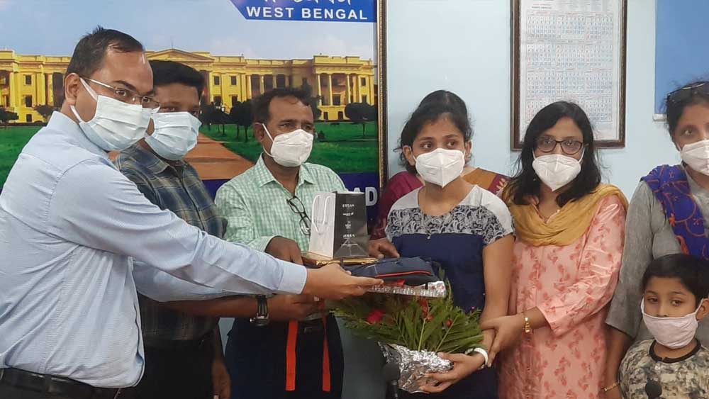 রুমনার হাতে পুরস্কার তুলে দিচ্ছেন জেলাশাসক। নিজস্ব চিত্র।