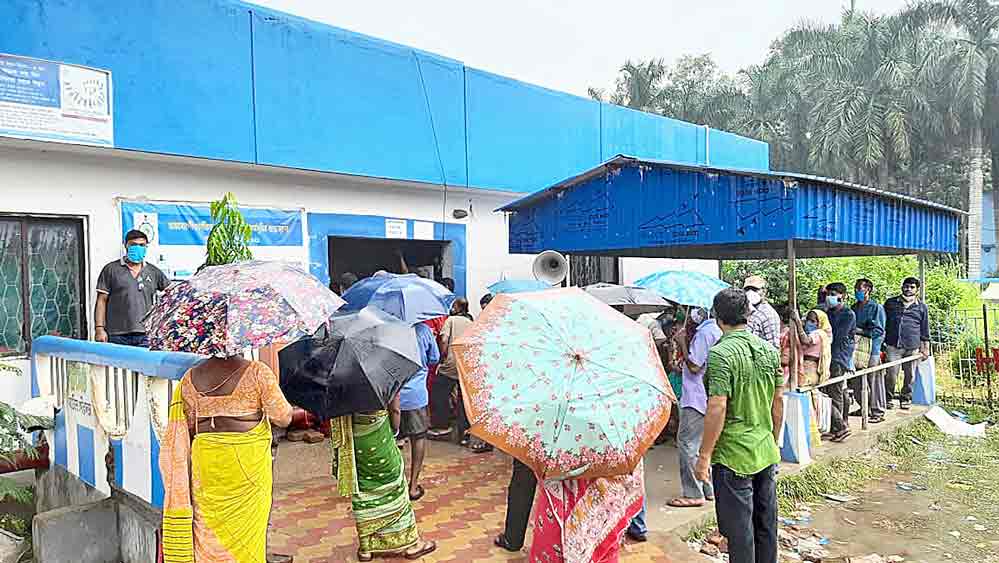 টিকার জন্য বৃষ্টিতেও লাইনে। ঘাটাল সুপার স্পেশালিটিতে। 