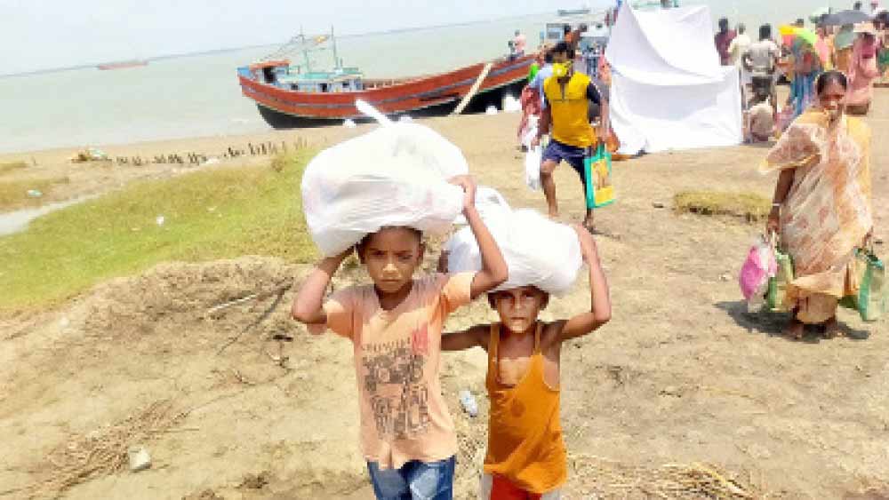 মুড়িগঙ্গা নদীর ঘোড়ামারা ঘাটে বিলি করা ত্রাণের খাবার নিয়ে ফিরছে দুই শিশু। ছবি: দিলীপ নস্কর