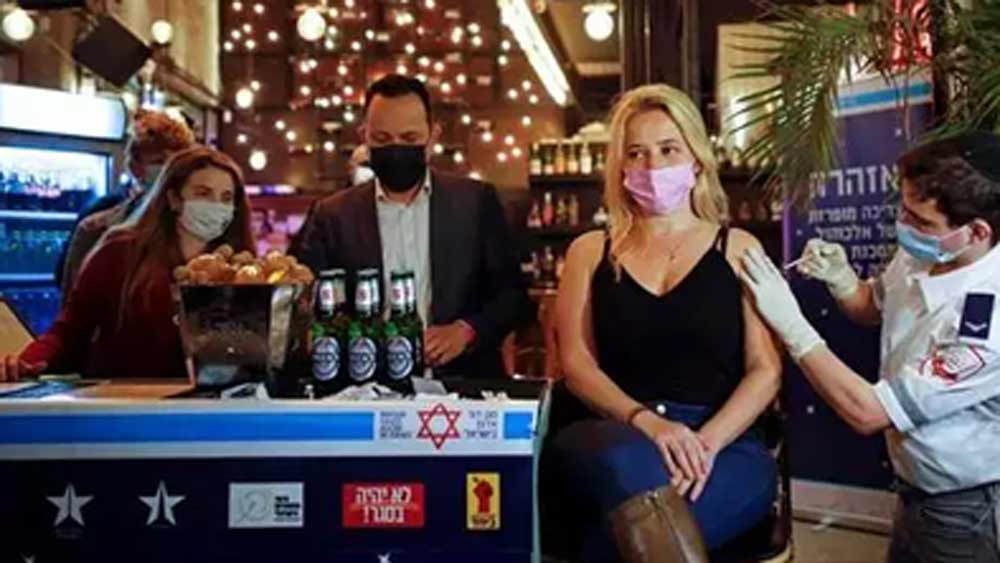 একটি টিকা নিলেই সম্পূর্ণ বিনামূল্যে পানীয়! ইজরায়েলের তেল আভিভে সাধারণ মানুষকে এ ভাবেই টিকা নিতে উৎসাহ দিয়েছে প্রশাসন। তার জন্য তেল আভিভের একটি পানশালাকেই টিকাকেন্দ্রে পরিণত করে ফেলা হয়েছিল।