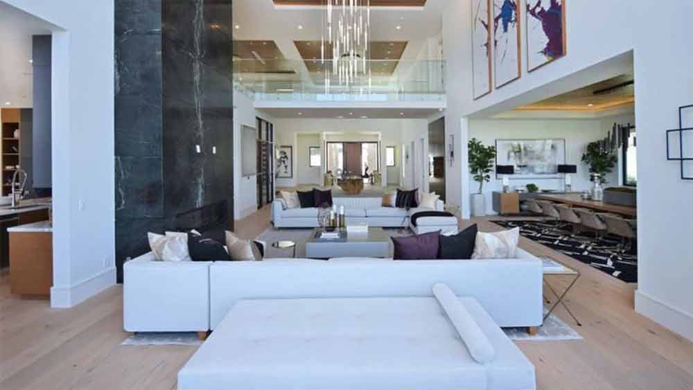 গোটা বাড়ির দেওয়াল দুধ সাদা নয়তো হালকা ক্রিম রঙের। বসার ঘরে তার সঙ্গে মেলানো ক্রিম রঙেরই সোফা। সঙ্গে কাঠের কফি টেবিল। পাথুরে দেওয়াল। আর হালকা হলুদ আলো।