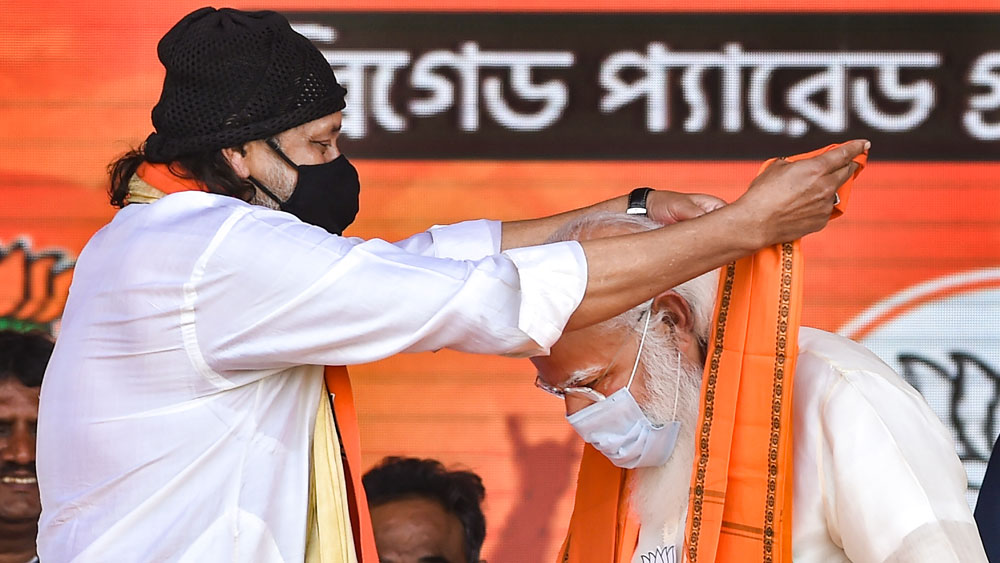 সেই বৃত্ত রবিবার পূর্ণ হল মোদীর ব্রিগেড মঞ্চে। ফের নতুন শিবিরে পা রাখলেন মিঠুন। বিজেপি কর্মী-সমর্থকদের নিজের ছায়াছবির সংলাপ বলে ‘উৎসাহ’ দিলেন। আবার মোদীর বক্তৃতার সময় শ্রোতার ভূমিকাও পালন করলেন। মোদী তৃণমূল নেত্রী মমতা বন্দ্যোপাধ্যায়কে কটাক্ষের সুরে বলেন, ‘‘কিছু দিন আগে স্কুটি সামলাচ্ছিলেন দিদি। সবাই ভয় পাচ্ছিলেন, আপনি পড়ে গিয়ে আঘাত না পান। ভাগ্যিস পড়ে যাননি। নইলে যে রাজ্যে স্কুটি তৈরি হয়েছে, সেই রাজ্যকেই শত্রু বানিয়ে ফেলতেন। তাই ভাল হয়েছে পড়ে যাননি। কিন্তু ভবানীপুর যেতে যেতে নন্দীগ্রামের দিকে কী করে ঘুরে গেল স্কুটি?’’ প্রধানমন্ত্রীর এই বক্তব্যের সময় উত্তরীয় দিয়ে মুখ চাপা দিয়ে হাসতেও দেখা গিয়েছে মিঠুনকে।