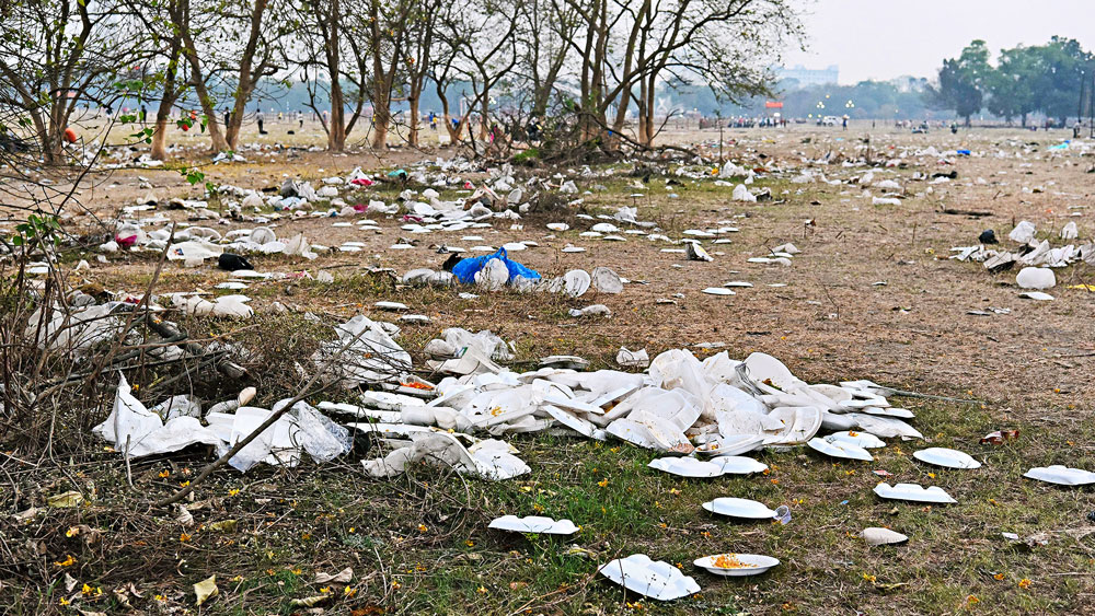 অপরিষ্কার: ব্রিগেডে সভার এক দিন পরে পড়ে রয়েছে থার্মোকলের থালা-বাটি। সোমবার। 