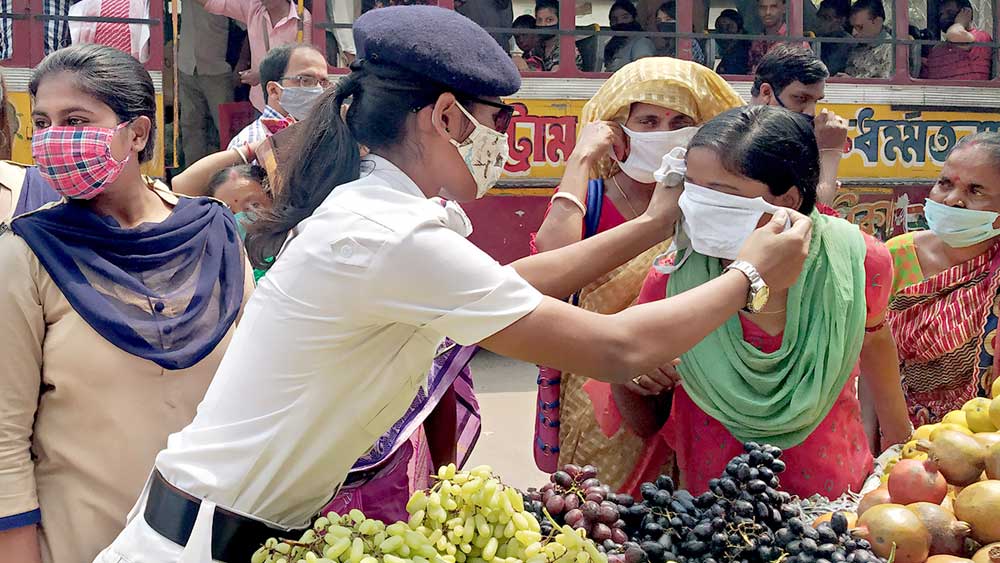 প্রয়াস: পুলিশের পক্ষ থেকে মাস্ক বিলি। মঙ্গলবার, হাওড়ার বঙ্গবাসী মোড়ের কাছে। ছবি: দীপঙ্কর মজুমদার