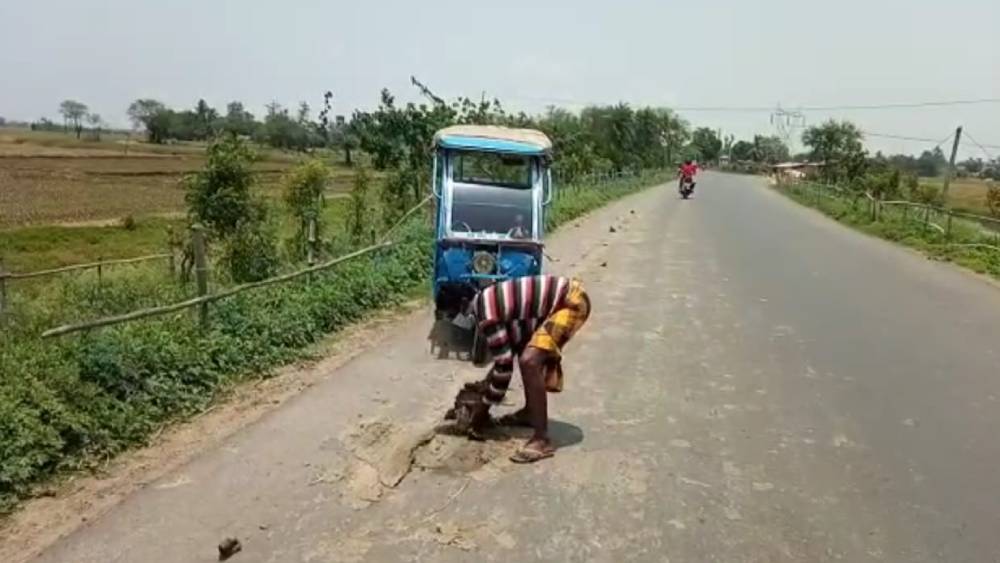 রাস্তা থেকে কাদা সরাতে ব্যস্ত শেখ কামালউদ্দিন।