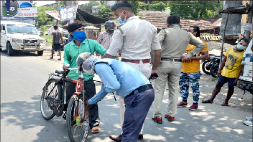 শাস্তি: কড়াকড়ির মধ্যে অকারণে রাস্তায় বেরনোয় সাইকেলের টায়ারের হাওয়া খুলে দিচ্ছে পুলিশ। রবিবার, বারাসতের হেলাবটতলায়। 