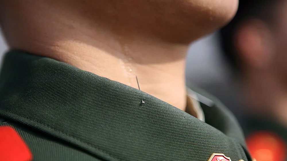 এক চিনা সেনার পোশাকের কলারে আলপিন গুঁজে রাখার এই ছবিটি ২০১২ সালের।