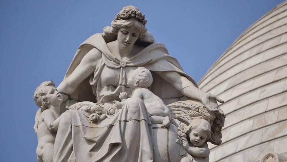 কেন্দ্রীয় ডোম বা চূড়াকে ঘিরে রয়েছে ৭টি প্রতীকী মূর্তি। এগুলি যথাক্রমে শিল্প, স্থাপত্য, দাক্ষিণ্য, ন্যায়বিচার, মাতৃত্ব, বিদ্যা ও প্রজ্ঞার অনুষঙ্গবাহী।