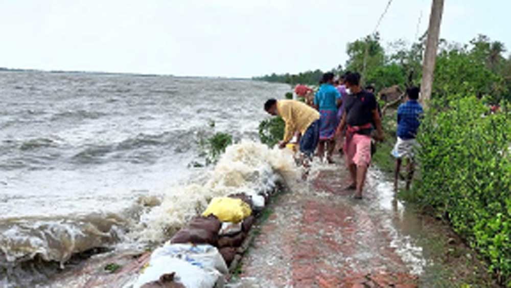 দশে-মিলি: ভাঙন রুখতে গ্রামবাসীরা বাঁধে মাটির বস্তা ফেলছেন। 