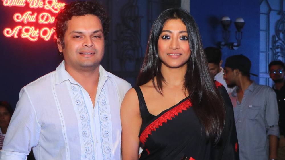 লাল পেড়ে কালো শাড়িতে পাওলি দাম এবং সাদা পোশাকে তাঁর স্বামী অর্জুন বিশেষ নজর কাড়লেন এই অনুষ্ঠানে।