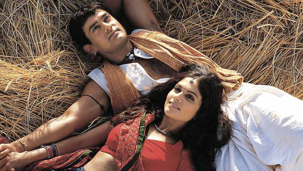 লগান: আমিরের ছবির দীর্ঘ তালিকায় এখনও ঝলমল করে ‘লগান’। জানেন কি, শাহরুখের জন্যই আশুতোষ গোয়ারিকরের ‘ভুবন’ হয়ে উঠতে পেরেছিলেন বলিউডের ‘পারফেকশনিস্ট’? প্রথমে এই চরিত্রে অভিনয়ের প্রস্তাব পেয়েছিলেন শাহরুখ। কিন্তু বন্ধু আশুতোষকে ফিরিয়ে দেন অভিনেতা। আমির খানকে নেওয়ার পরামর্শ দিয়েছিলেন পরিচালককে। তখনও দুই খানের বন্ধুত্বে প্রতিদ্বন্দ্বিতার আঁচ পড়েনি। শাহরুখের ছেড়ে দেওয়া চরিত্রে তাই ঢুকে পড়েন আমির।  