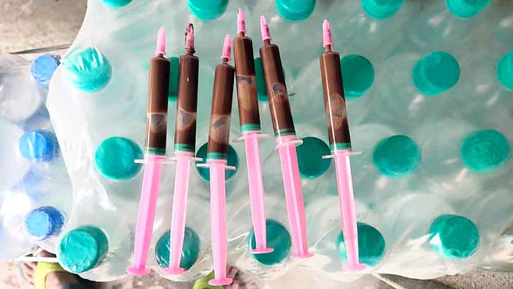 n মশাট বাজারে মঙ্গলবারও বিক্রি হচ্ছে সিরিঞ্জ চকলেট। 