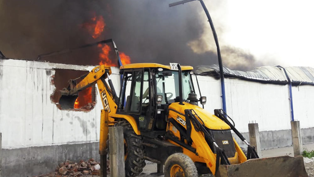 আগুন আয়ত্তে আনতে ভাঙা হচ্ছে কারখানার দেওয়াল।