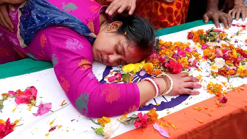 শোকস্তব্ধ: শ্যামলবাবুর কফিন আঁকড়ে তাঁর স্ত্রী সুপর্ণা দাস। 