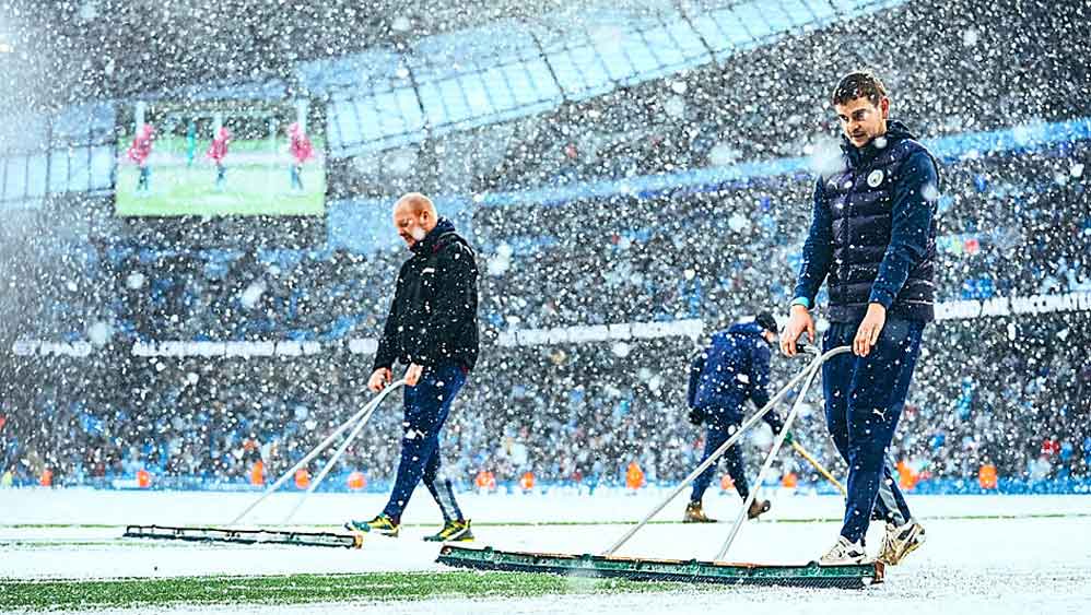 বিপত্তি: বরফে ঢাকা ম্যান সিটির মাঠ। চলছে পরিষ্কারের কাজ।