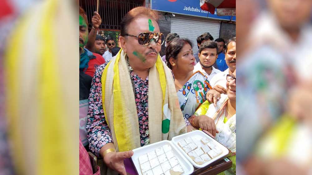 যদুবাবুর বাজারে মিষ্টি বিতরণ কামারহাটির তৃণমূল বিধায়ক মদন মিত্রের। নিজস্ব চিত্র।