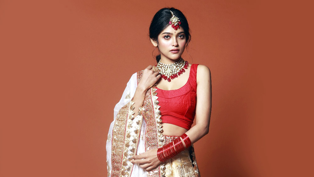 মুহূর্তে বদলে গেল সাজ। শাড়ির বদলে এ বার লেহেঙ্গা চোলি। সাদা-লালের সমন্বয় এবং উৎসব— এই চিরন্তন জুটির যে কোনও তুলনা নেই আজও, তা অনুষা আবার বুঝিয়ে দিলেন।