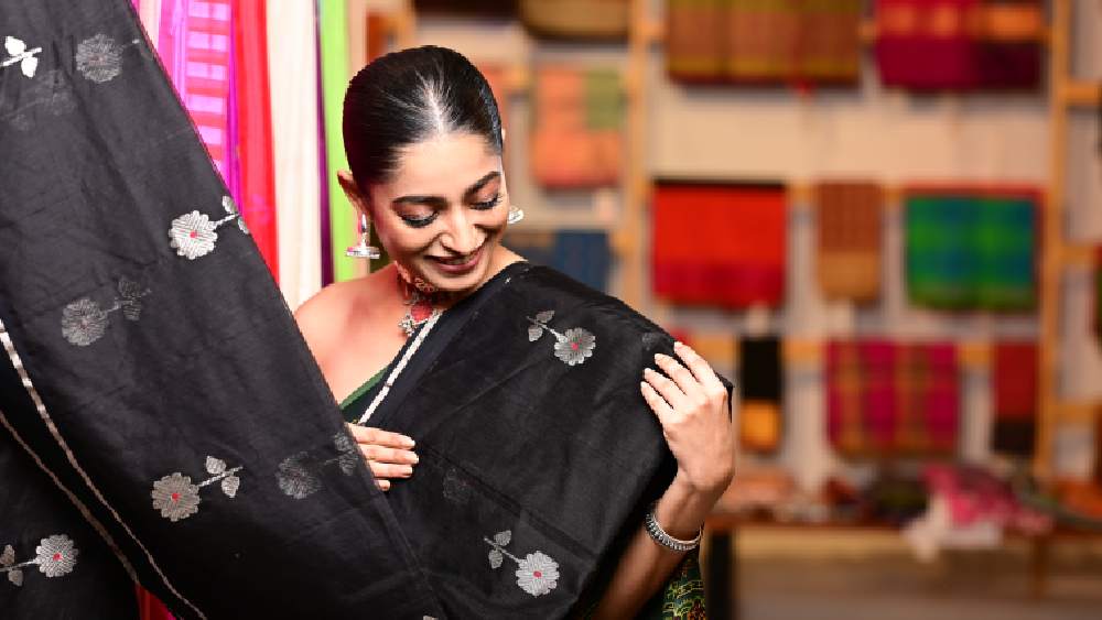 প্রথমেই তাঁর চোখ টানল একটি কালো চান্দেরী শাড়ি। কালোর উপর রুপোলি জরির হাল্কা কারুকাজ করা শাড়িটি দেখেই নিয়ে নিলেন ইশা।