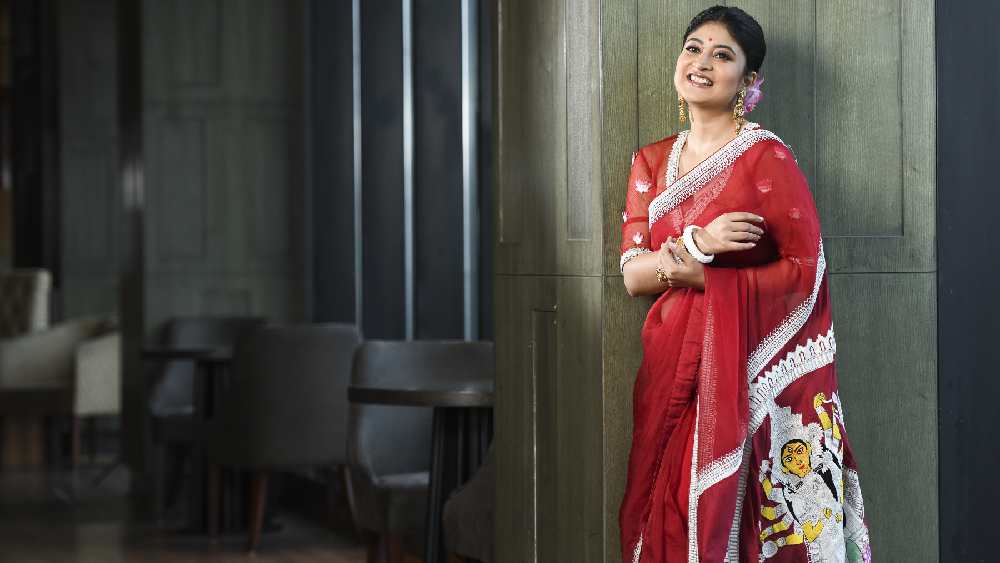 কিন্তু লাল-পাড় সাদা শাড়িরও সময়ের সঙ্গে রূপ বদলায়। তাই সনাতনী গরদের শাড়ির বাইরে মেয়েরা এখন পছন্দ করেন অন্য ধরনের শাড়ি। সন্দীপ্তাও সেই রীতি মেনে এ বারের পুজোয় বেছে নিয়েছেন সাদা লেসের পাড় দেওয়া লাল অর্গ্যানজা শাড়ি।