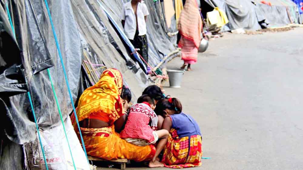 পথেই জীবন: জল নামলেও বাড়ি বাসের অযোগ্য। দিন কুড়ি হল খড়্গপুর-ময়না রাজ্য সড়কের ধারে এই ঝুপড়িতেই রয়েছেন বহু বন্যা-দুর্গত। 