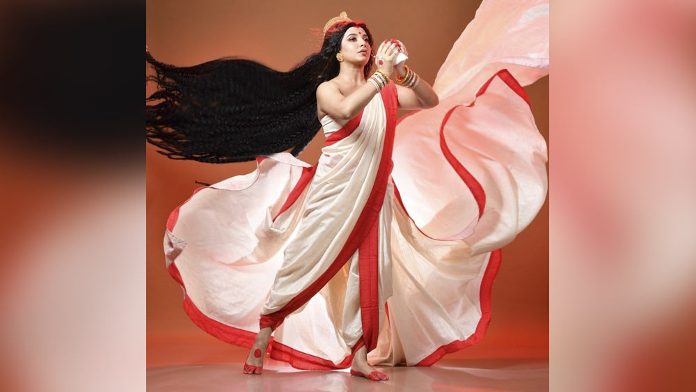 অভিনেত্রী শুভশ্রী গঙ্গোপাধ্যায় এ বছর জি বাংলার মা দুর্গা। শাঁখ বাজানোর ভঙ্গীতে যেন ঘরের মেয়ে। আটপৌরে লাল পাড় সাদা শাড়ির ছবিতেই নজর কেড়েছেন নিমেষে।