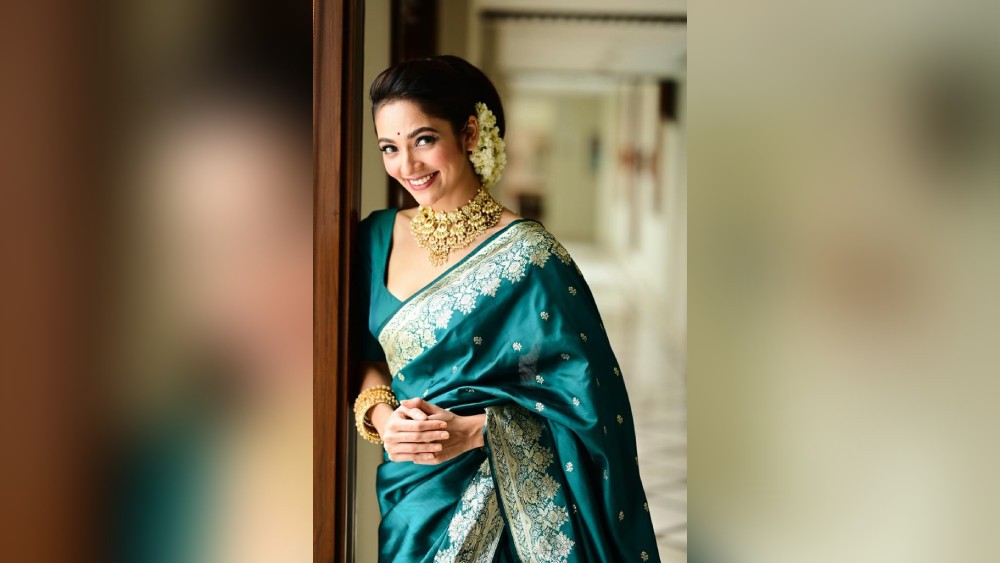গয়নার মতো পরনের শাড়িটিও বেশ ভারী কাজের। একরঙা নীল শাড়িতেও নায়িকা যেমন সুমিষ্ট, তেমনই মোহময়ী।