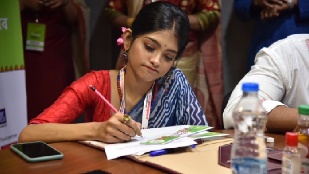 অনুষা সেজে উঠেছেন নীল শাড়িতে। চুলে গোলাপি ফুল। কপালে ছোট্ট টিপ, ঠোঁটে গাঢ় লাল লিপস্টিক।