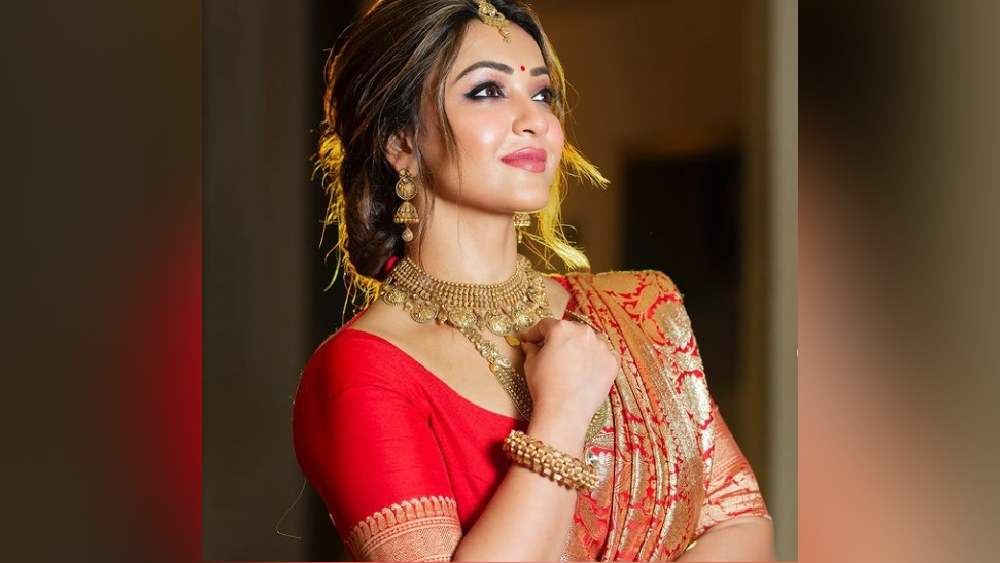 লাল বেনারসী শুধু কি কনেদের জন্যই? সেই ধারণা উড়িয়েই কৌশানী সেজে উঠলেন পুজোর দিনে। সঙ্গে কালচে-সোনালি ভারী গয়না। পোশাক-গয়না মিলিয়ে বেশ জমকালো। ভারসাম্য বজায় রাখতে ঠোঁটে হাল্কা রং। যত্নে বেঁধেছেন চুলও।