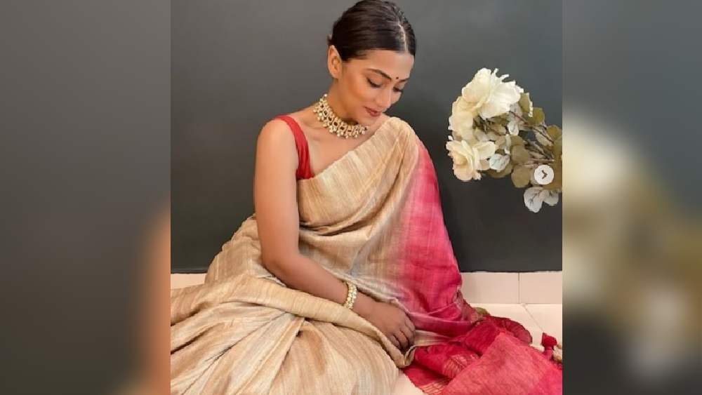তসর সিল্ক আর হাতকাটা লাল ব্লাউজ— বরাবরের মতোই সাজ নিয়ে সচেতন অনিন্দিতা। মানানসই গয়না, টানটান করে বাঁধা চুল আর কপালে ছোট্ট টিপ! অনিন্দিতার সাজ টেক্কা দিতে পারে অনেকের জমকালো বাছাইকেই।