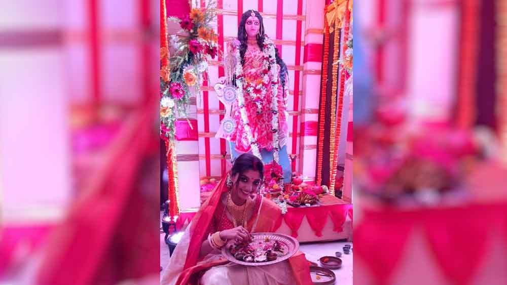 চওড়া জরি পাড় সাদা বেনারসি। সিঁথিতে সিঁদুর। গা ভরা গয়না। মাথায় ঘোমটা টেনে পুজোর সন্ধেয় উত্তমকুমারের নাতবৌ নিজেই লক্ষ্মীমন্ত।