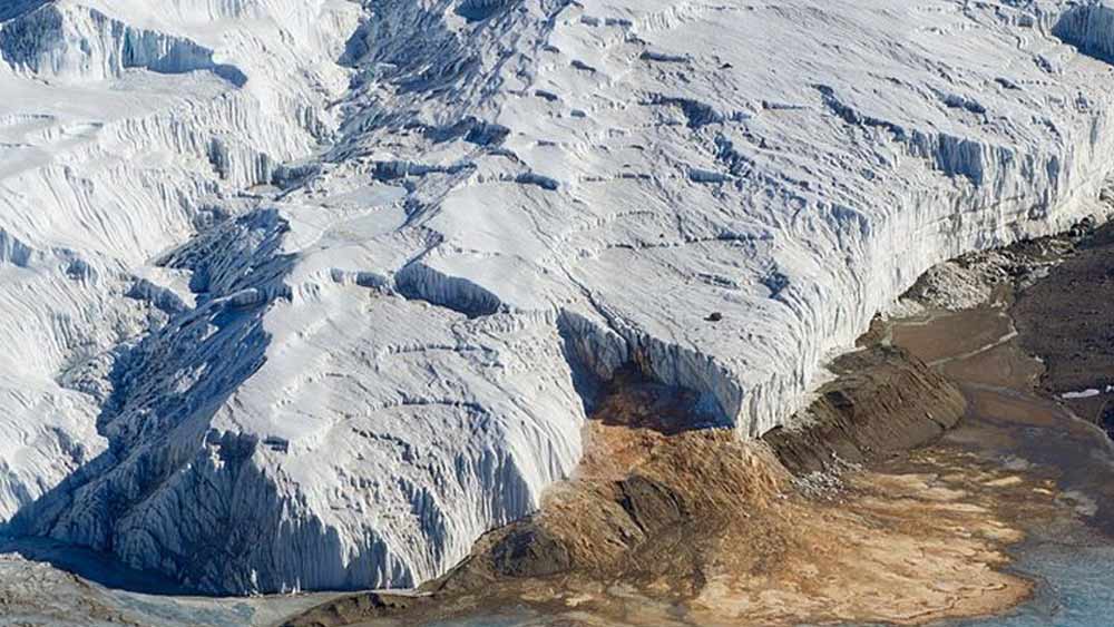 হিমবাহের কোনও অংশে চিড় থাকলে সেই পথ দিয়েই বেরিয়ে আসে ওই হ্রদের লাল জল। দেখে মনে হয় হিমবাহ চিড়ে যেন রক্ত ঝরে পড়ছে।