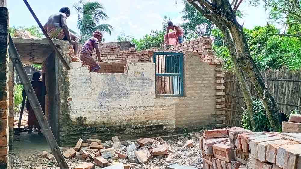 সম্বল: ভাঙনের আতঙ্কে পাকা ঘর ভাঙা চলছে মালদহের বীরনগরের রবিদাস পাড়ায়। মঙ্গলবার। 