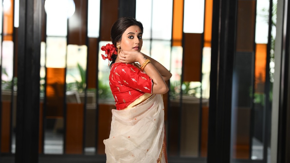 চুলের ভাঁজ ঠিক করতে করতে স্বস্তিকা বললেন, ‘‘এ রকম সাজে নিজেকে আগে দেখিনি। বুকুনদির জন্য নিজেকে নিয়ে পরীক্ষানিরীক্ষা করার সাহস আর উৎসাহ পেলাম। সাধারণত আমরা মাথায় জুঁই বা গোলাপ ফুল দিই। জবা ফুল মাথায় দেব, এমনটি ভাবতে পারতাম না। আনন্দবাজার অনলাইনের জন্য সেই ফুল মাথায় পরেছি। বুঝলাম নিজেকে ঠিক মতো সাজিয়ে তুলতে পারলে, আত্মবিশ্বাস থাকলে, সেই সাজ মানুষ গ্রহণ করবেনই।’’