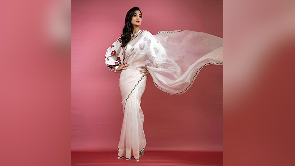 ভারতীয় পোশাকে সব সময়ে স্বচ্ছন্দ তিনি। সে বিতর্কের কেন্দ্রে থাকুন বা না থাকুন। এক রঙা সাবেক স্বাদের শাড়ির সঙ্গে হাল ফ্যাশনের ব্লক প্রিন্ট করা ব্লাউজ নতুনত্ব আনতে পারে পুজোর সাজেও। শিল্পা শেট্টির মতো সাদা শাড়ি না হোক, কোনও অতি উজ্জ্বল রঙে সরু পাড়ের শিফন শাড়িতেওপুজোর একটি দিন নিজের সাজে আনা যায় বলিউডের আমেজ।