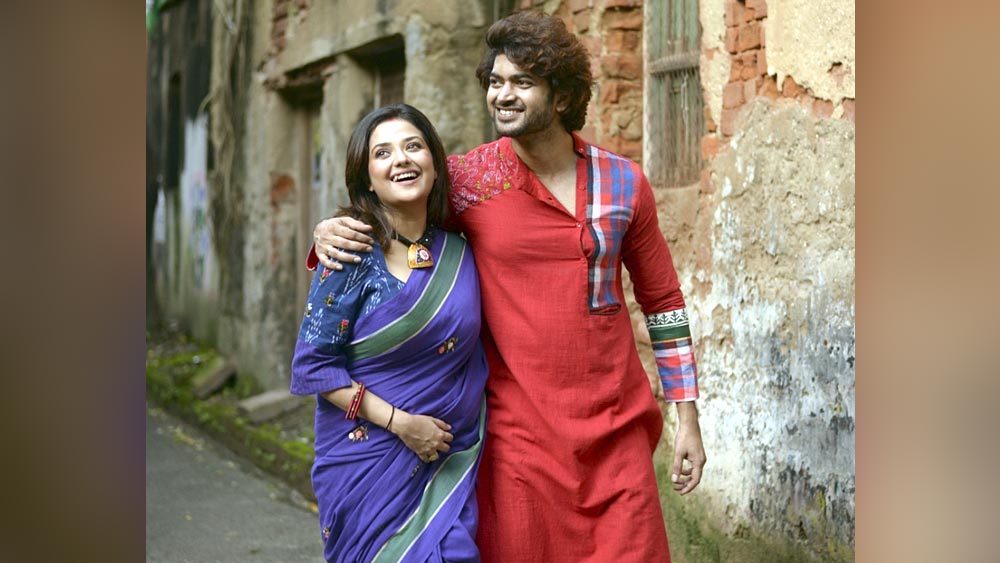 মিমির বেগনি শাড়ির সঙ্গে ওমের জন্য মানানসই পাঞ্জাবি বেছে নিয়েছেন অনুশ্রী। লাল খাদির পাঞ্জাবির উপর স্থানীয় শিল্পীদের তৈরি গামছা, ব্লক প্রিন্ট এবং কাঁথার কাজ। তাঁর কথায়, “মিমির উজ্জ্বল বেগনি শাড়ির কথা মাথায় রেখেই ওমের জন্য এই পাঞ্জাবি বেছে নিয়েছি। দু’জনকে একসঙ্গে আরও বেশি মানাচ্ছে।”