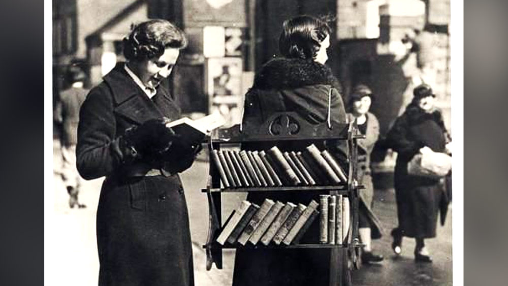 পিঠে ব্যাগের মতো করে বাঁধা  রয়েছে কাঠের তৈরি দু’টি তাক। সেই তাকের মধ্যে থাকে থাকে রাখা একগুচ্ছ বই। খুবই অল্প দামে সেই বইগুলো বিক্রি করতেন এই ‘ওয়াকিং লাইব্রেরি’রূপী বই-বিক্রেতারা।