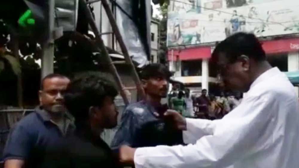 যুবকের কলার ধরেছেন রবীন্দ্রনাথ ঘোষ।