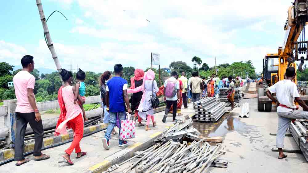 বিপজ্জনক: পুলিশের নির্দেশ অমান্য করেই সেতুর উপর দিয়ে পারাপার করছেন অনেকেই। ছবি: স্বরূপ সরকার