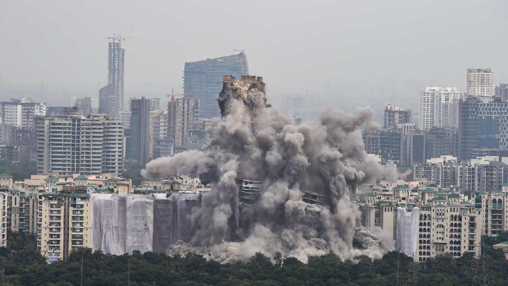 নয়ডার ওই এলাকায় বেআইনি ভাবে নির্মিত জোড়া অট্টালিকা আপাতত ধুলো বালিতে পর্যবসিত। রাজধানী দিল্লির সুউচ্চ স্তম্ভ কুতুব মিনারের থেকেও উঁচু দু’টি ইমারতকে ৩৫ হাজার কেজি বিস্ফোরক ব্যবহার করে মাটিতে মিশিয়ে দেওয়া হয়েছে। একটি সংবাদ সংস্থার রিপোর্ট বলছে, ৩৫ হাজার কেজি বিস্ফোরকের ক্ষমতা ভারতের প্রতিরক্ষা ক্ষেত্রে ব্যবহৃত বেশ কয়েকটি শক্তিশালী ক্ষেপণাস্ত্রের থেকেও বেশি। 